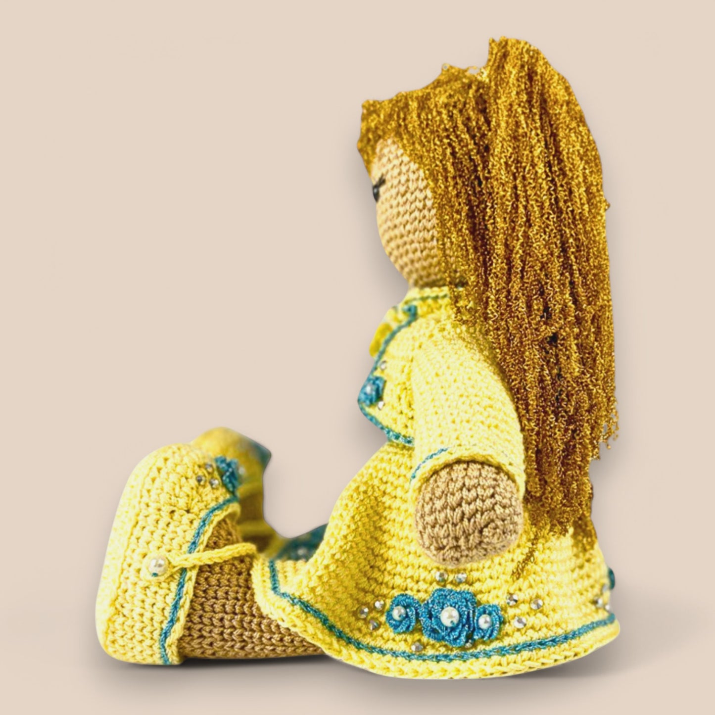 side view of crochet doll showcasing her flower embroidered skirt and shoes