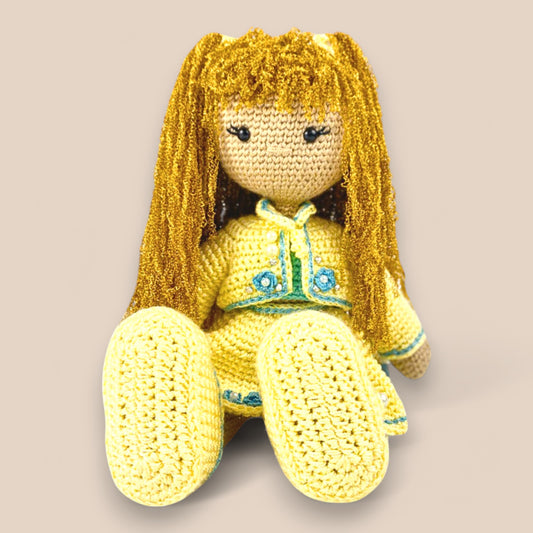 sitting view of handcrafted crochet doll.