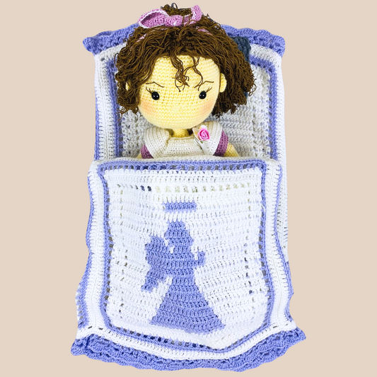 white handmade crochet blanket with angel in motifs. all handmade with acrylic wool .a crochet doll sleeping iwth angel covering her in form of blanket