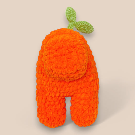 Orange handcrafted crochet toy with white face and greenleaf on top back view 