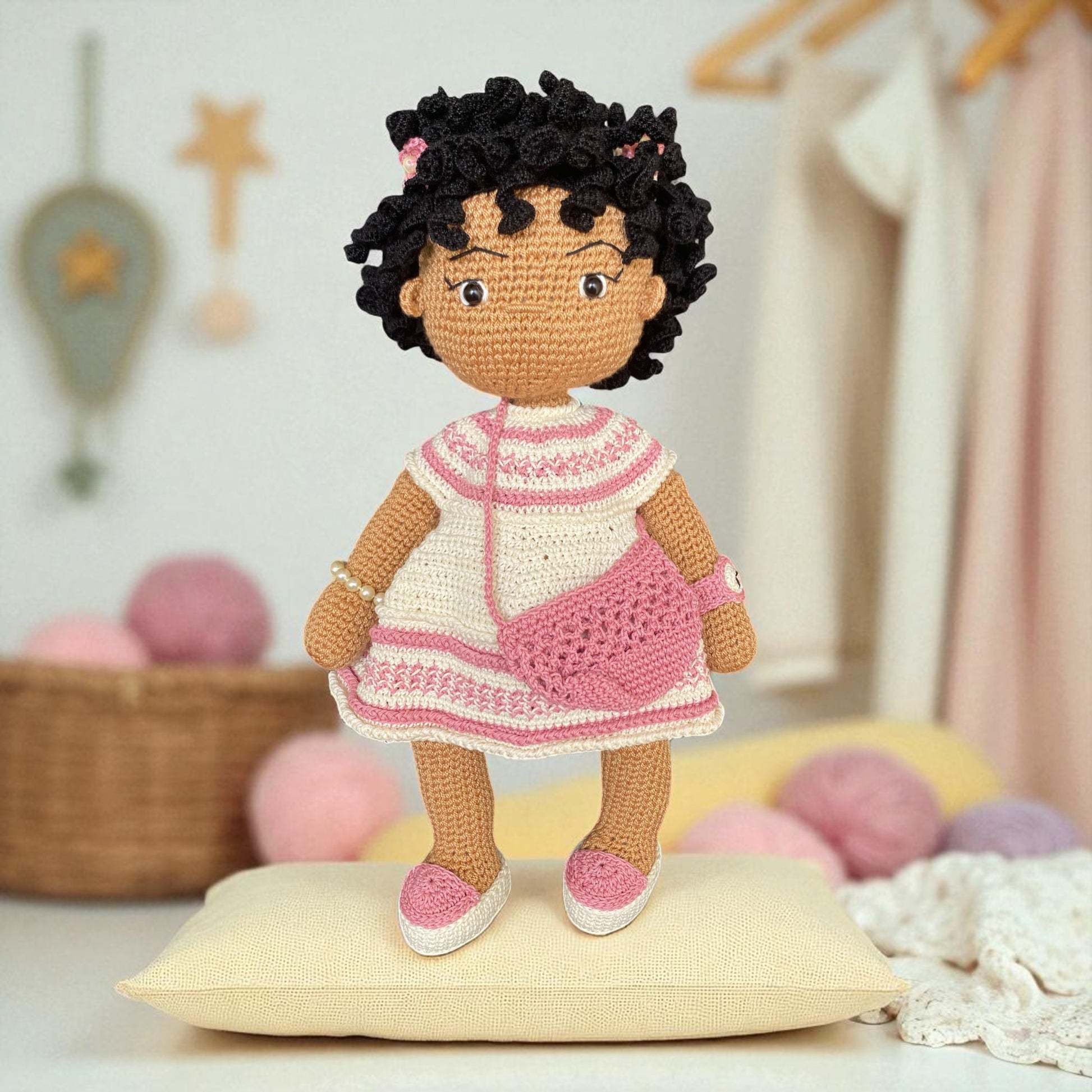 Crocheted doll with a pink dress in a cozy room setting