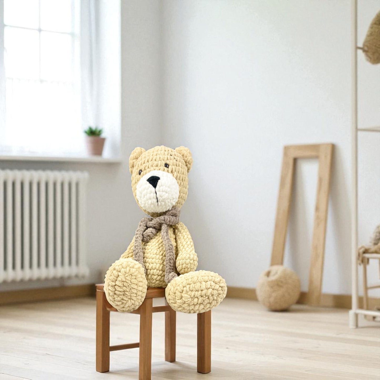 Knitted teddy bear sitting on a wooden chair in a room with light-colored walls and a window.